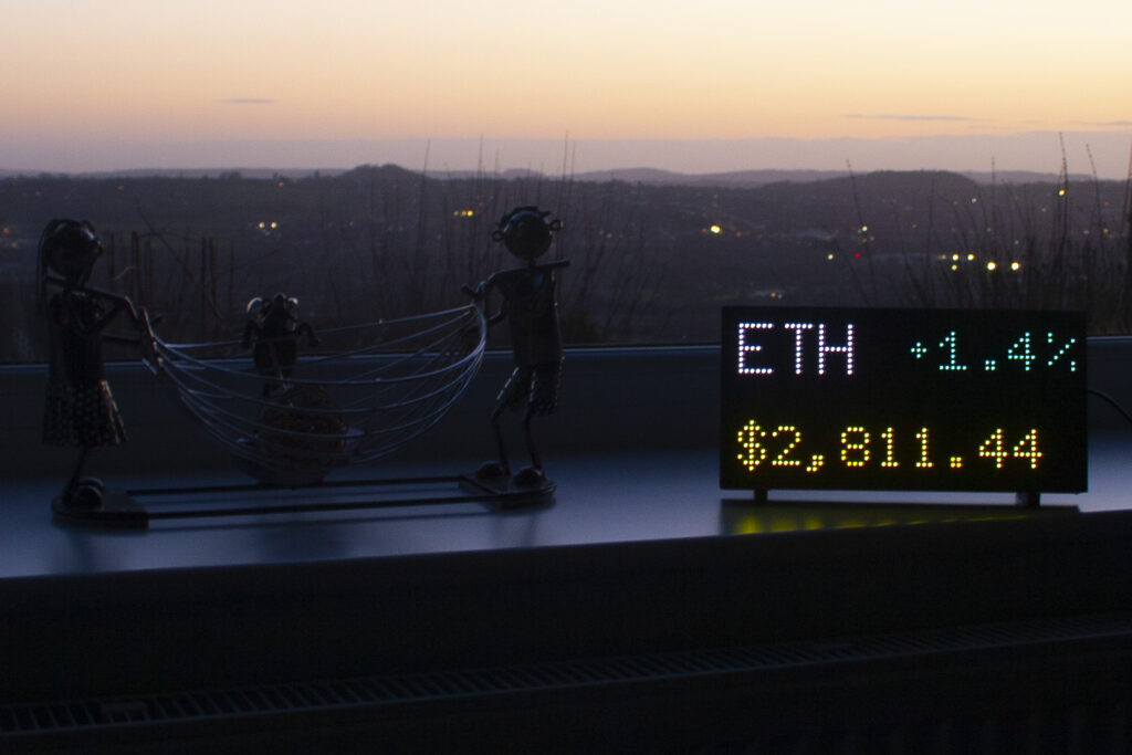 Ethereum price in text mode beside a window at sunset